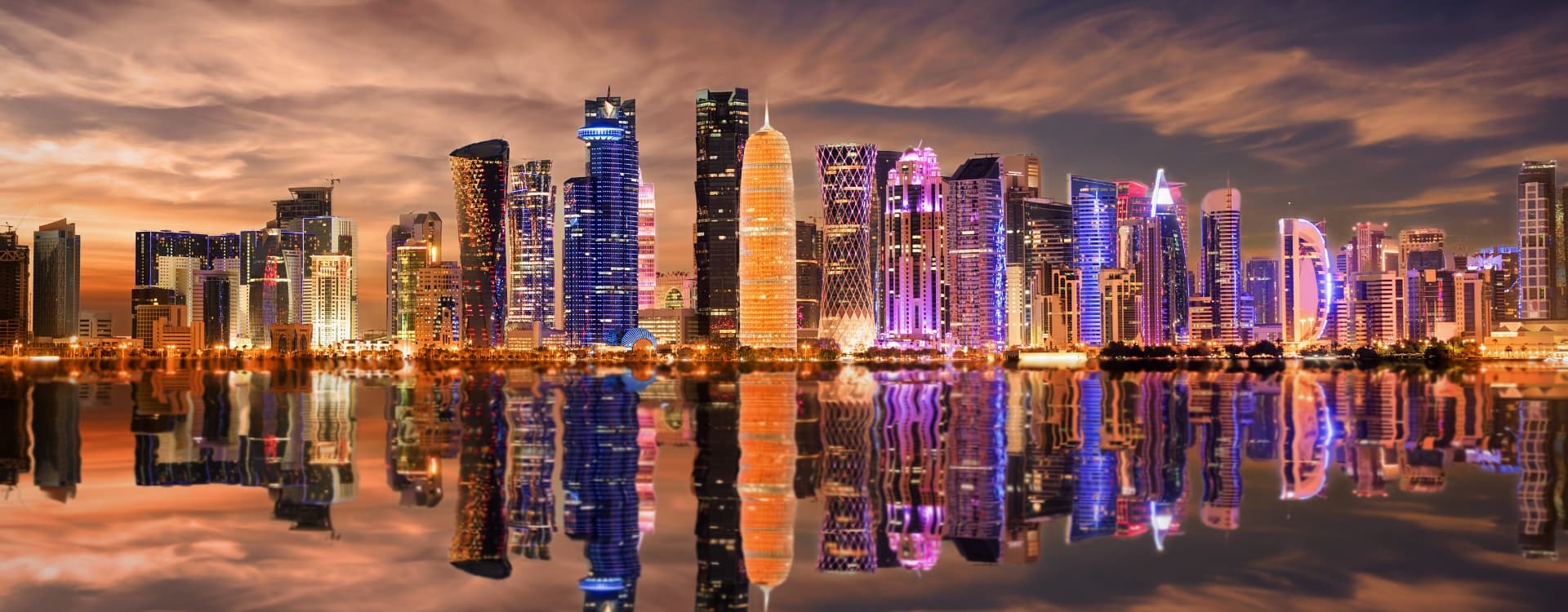 Panoramic View Of Illuminated Doha With Reflections In The Bay Qatar